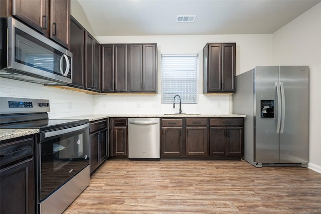 900 Juneberry Dr, Denton, TX 76207 - kitchen with a sink, dark brown cabinetry, appliances with stainless steel finishes, and light wood-style flooring