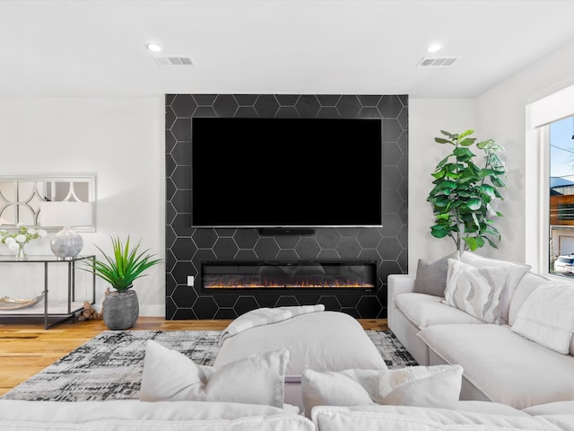 living room with visible vents, recessed lighting, a large fireplace, and wood finished floors