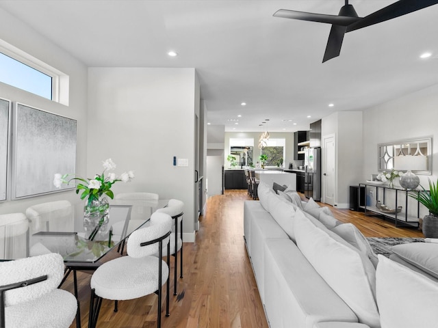 living area featuring recessed lighting, baseboards, light wood-style floors, and a healthy amount of sunlight