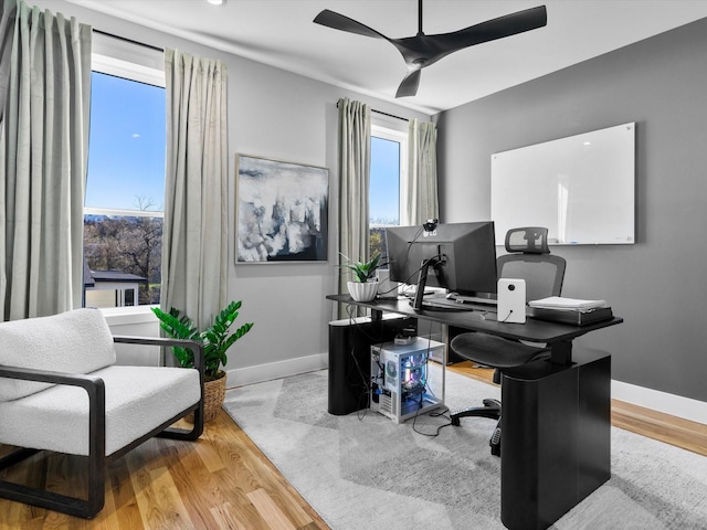 office space featuring wood finished floors, baseboards, and ceiling fan