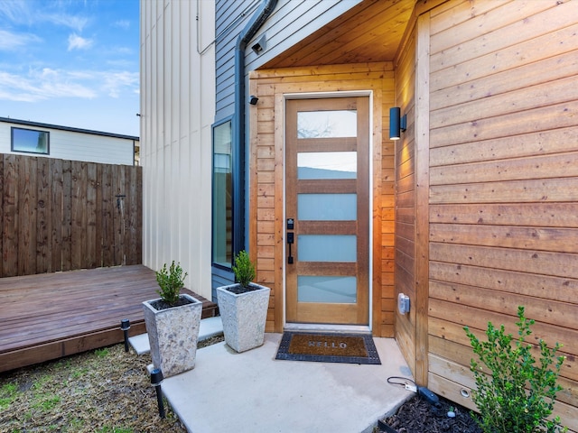 property entrance with a deck and fence