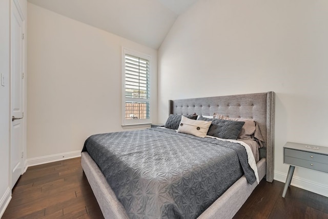 bedroom with baseboards, lofted ceiling, and dark wood finished floors