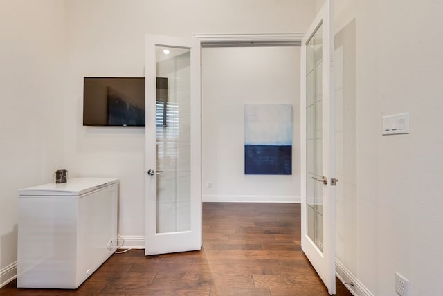 hall with french doors, baseboards, and wood finished floors