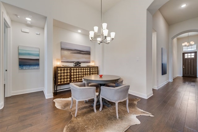 dining area with an inviting chandelier, wood finished floors, arched walkways, and baseboards