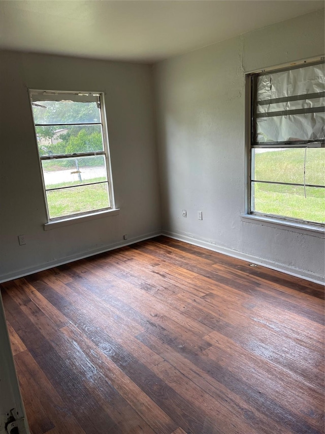 unfurnished room featuring hardwood / wood-style floors, baseboards, and a wealth of natural light