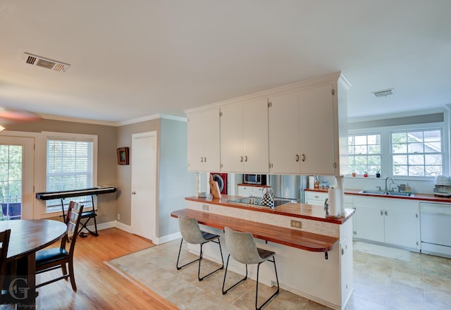 kitchen featuring visible vents, dishwasher, stainless steel microwave, and a sink