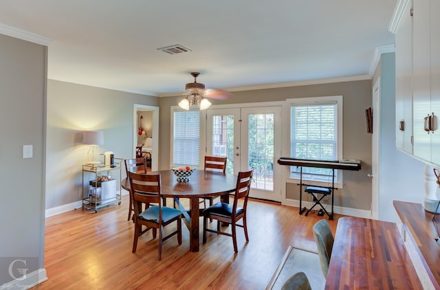 dining space with visible vents, crown molding, baseboards, ceiling fan, and light wood-style flooring