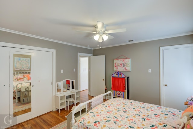 bedroom featuring visible vents, a ceiling fan, wood finished floors, a closet, and crown molding