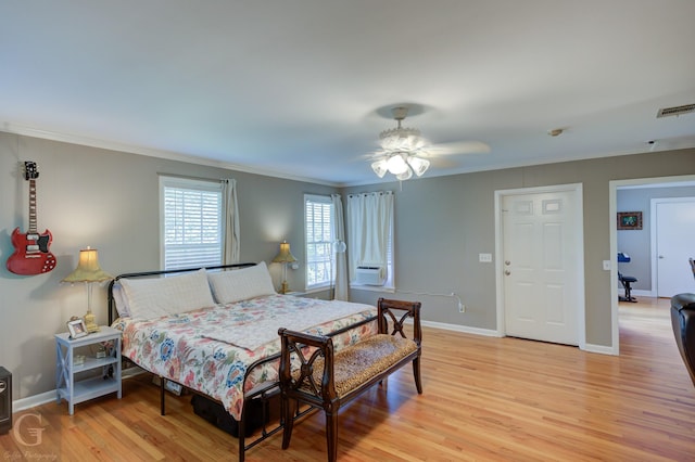 bedroom featuring visible vents, crown molding, ceiling fan, baseboards, and light wood-style floors