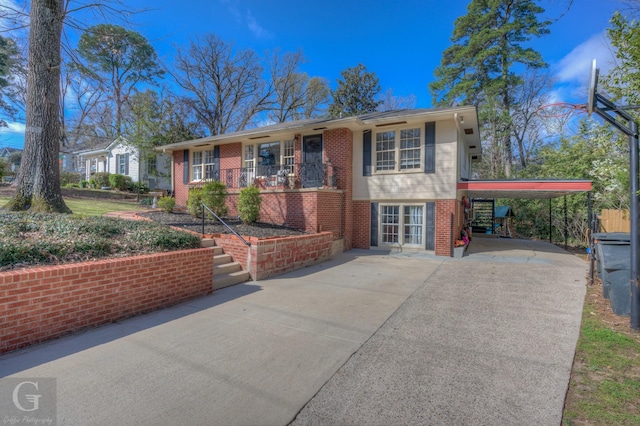 single story home featuring brick siding, an attached carport, driveway, and french doors