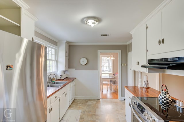 kitchen featuring visible vents, crown molding, under cabinet range hood, stainless steel appliances, and a sink