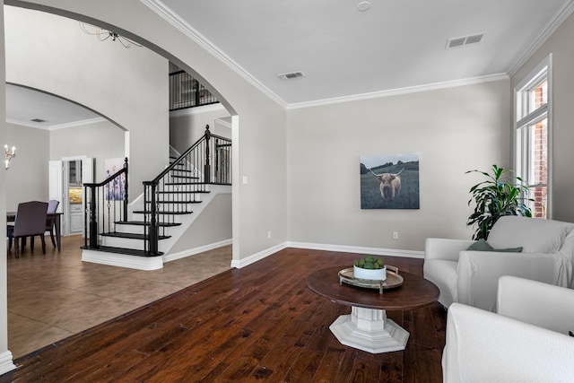 living area featuring visible vents and crown molding