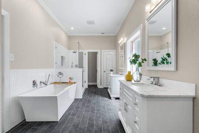 bathroom featuring two vanities, ornamental molding, a sink, a shower stall, and a freestanding bath