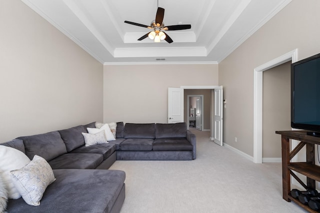 living area with light carpet, a raised ceiling, a ceiling fan, and ornamental molding