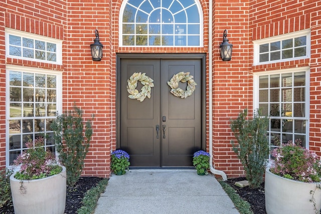 property entrance featuring a garage and brick siding