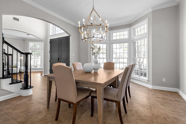 tiled dining room featuring visible vents, baseboards, stairway, ornamental molding, and arched walkways