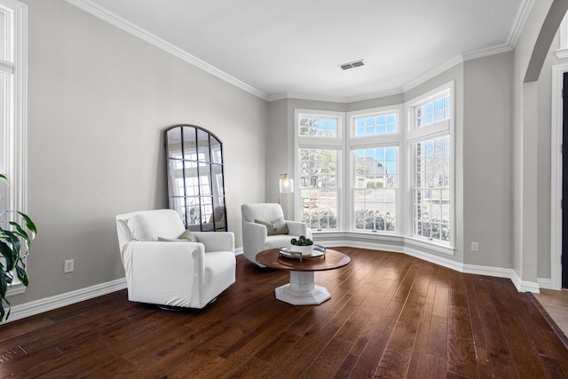 living area featuring visible vents, baseboards, dark wood finished floors, and ornamental molding