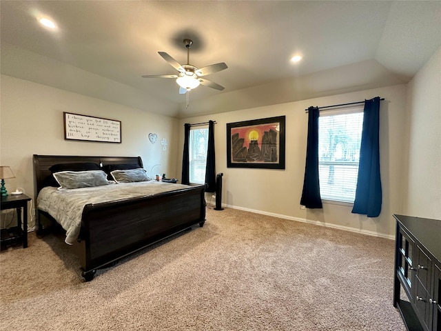 bedroom with baseboards, light colored carpet, recessed lighting, a raised ceiling, and a ceiling fan