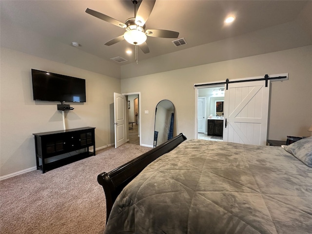 carpeted bedroom featuring a barn door, baseboards, and visible vents