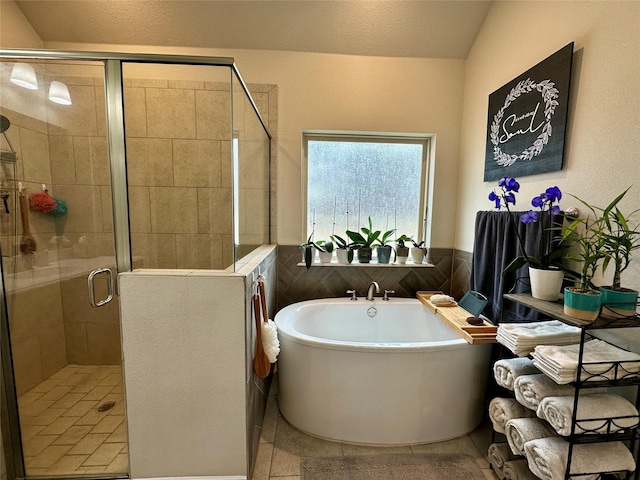 bathroom featuring a shower stall, a freestanding tub, tile walls, and wainscoting