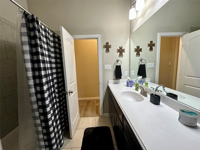 full bath featuring a shower with shower curtain, baseboards, vanity, and tile patterned floors