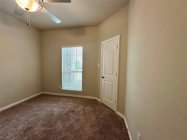 carpeted empty room featuring baseboards and ceiling fan