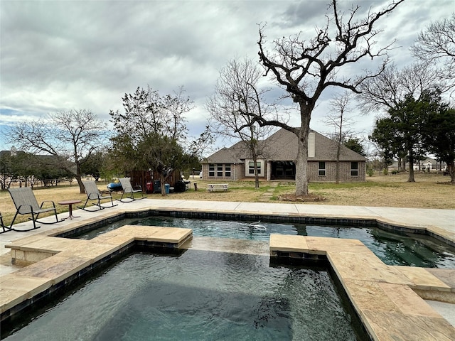 exterior space featuring an in ground hot tub, a yard, and a patio area