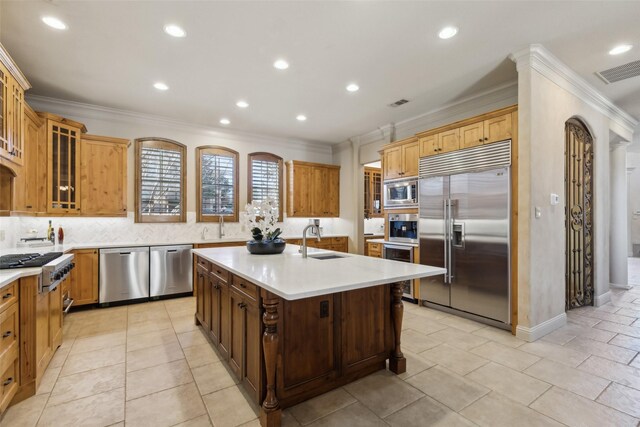 kitchen featuring a sink, stainless steel appliances, ornamental molding, and light countertops