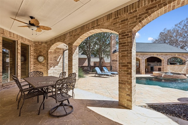 view of patio with a pool with connected hot tub, ceiling fan, outdoor dining space, and fence