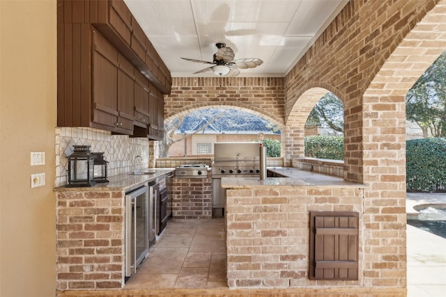 view of patio / terrace featuring a sink, ceiling fan, and exterior kitchen