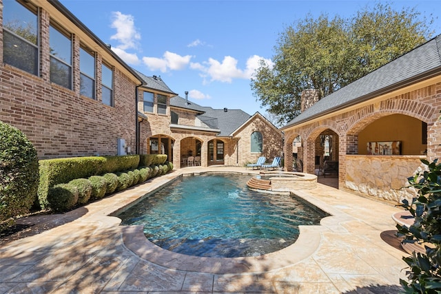 view of pool with a patio and a pool with connected hot tub