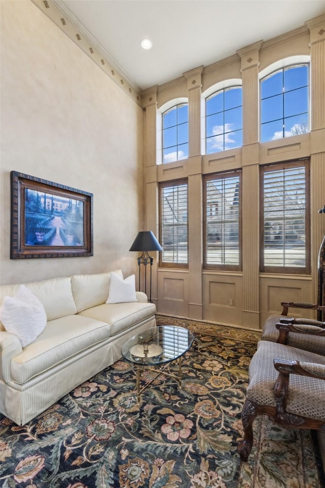 living room featuring a high ceiling and ornamental molding