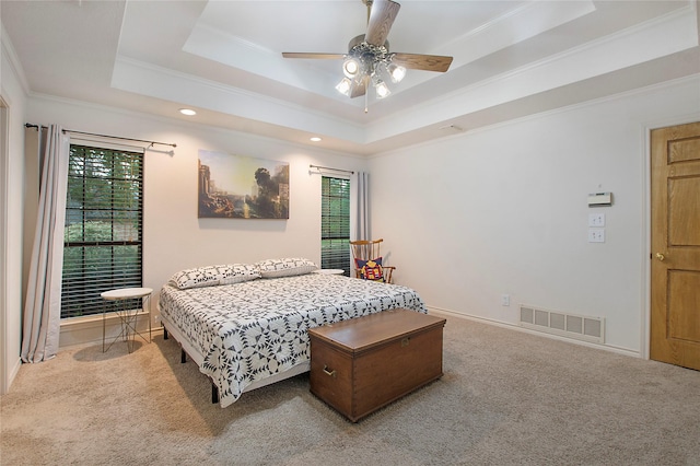 bedroom featuring visible vents, baseboards, carpet floors, ornamental molding, and a raised ceiling