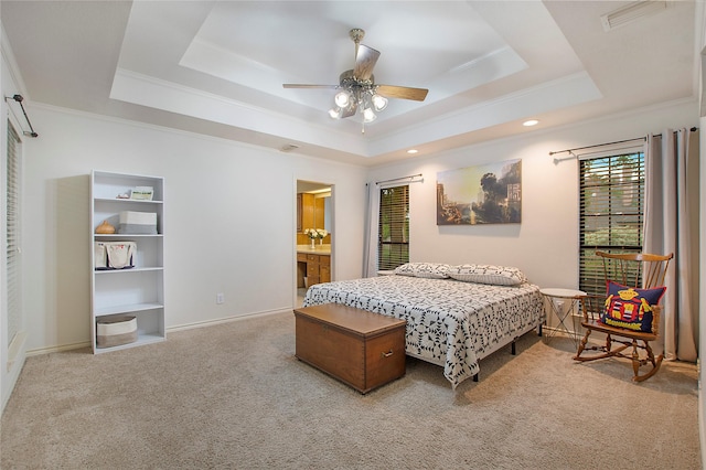 bedroom featuring baseboards, carpet floors, visible vents, a tray ceiling, and crown molding