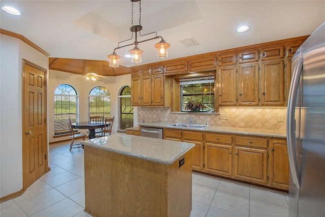 kitchen featuring a sink, a kitchen island, tasteful backsplash, appliances with stainless steel finishes, and a raised ceiling