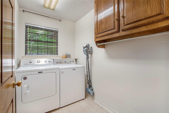 laundry room with light tile patterned floors, baseboards, cabinet space, and separate washer and dryer