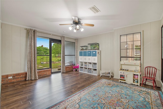 recreation room with ceiling fan, visible vents, wood finished floors, and crown molding