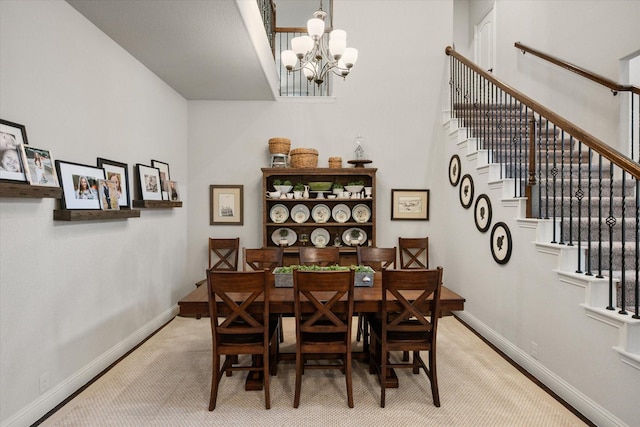 dining space with a chandelier, stairway, baseboards, and carpet