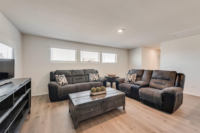 living area featuring light wood-style flooring, a healthy amount of sunlight, and baseboards