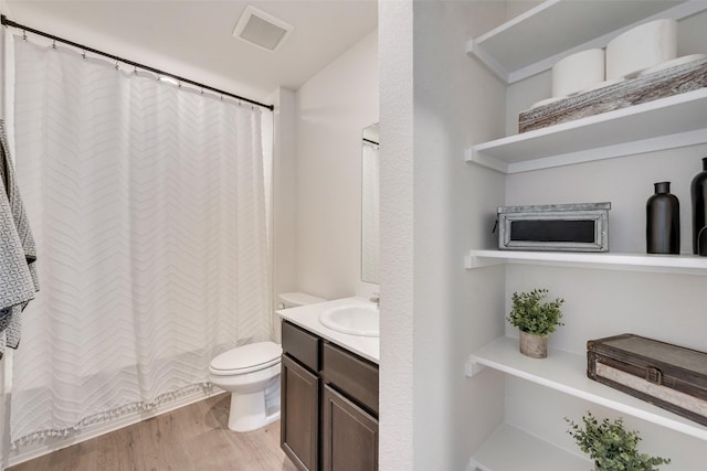 bathroom featuring visible vents, toilet, vanity, and wood finished floors