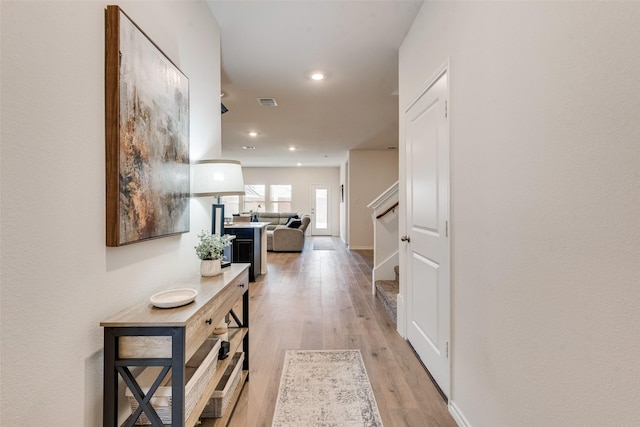 hallway with visible vents, baseboards, recessed lighting, stairs, and light wood-type flooring