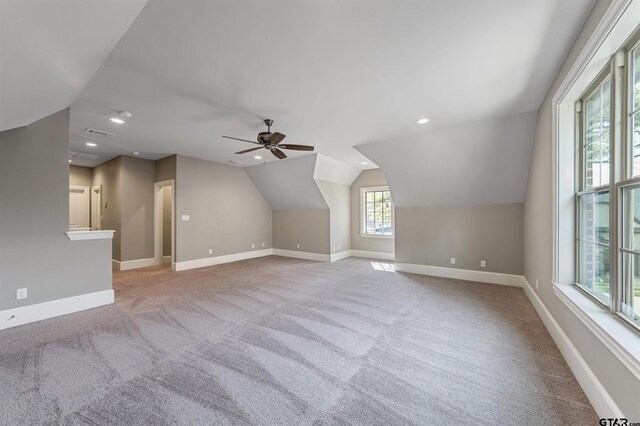 additional living space featuring carpet flooring, baseboards, and vaulted ceiling