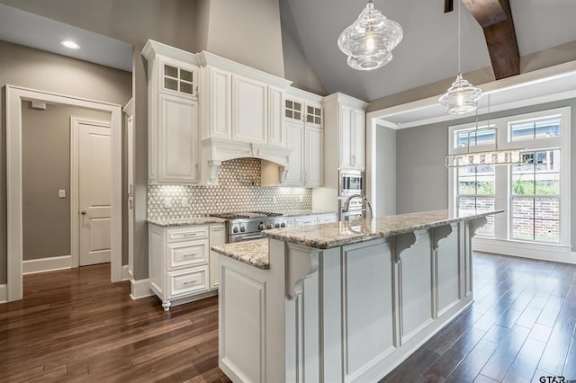 kitchen featuring decorative backsplash, lofted ceiling with beams, appliances with stainless steel finishes, glass insert cabinets, and dark wood-style flooring