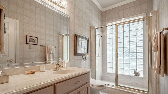 full bath with toilet, a stall shower, ornamental molding, tile walls, and vanity