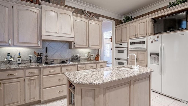 kitchen featuring white appliances, light stone counters, a kitchen island, ornamental molding, and tasteful backsplash