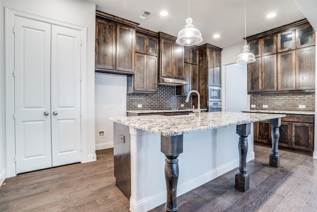 814 Davids Way, Allen, TX 75013 - kitchen featuring oven, visible vents, dark brown cabinetry, and wood finished floors