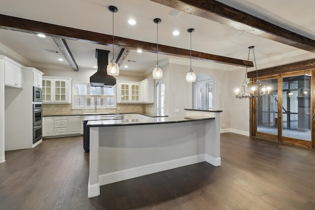 kitchen featuring dark countertops, white cabinets, dark wood-style flooring, and island range hood