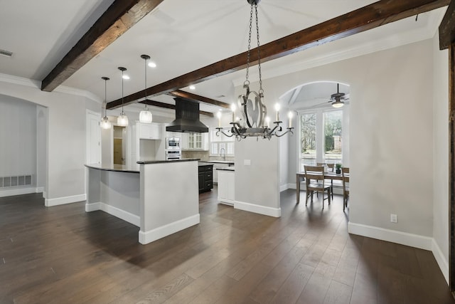 kitchen with visible vents, dark wood-type flooring, a peninsula, island exhaust hood, and arched walkways