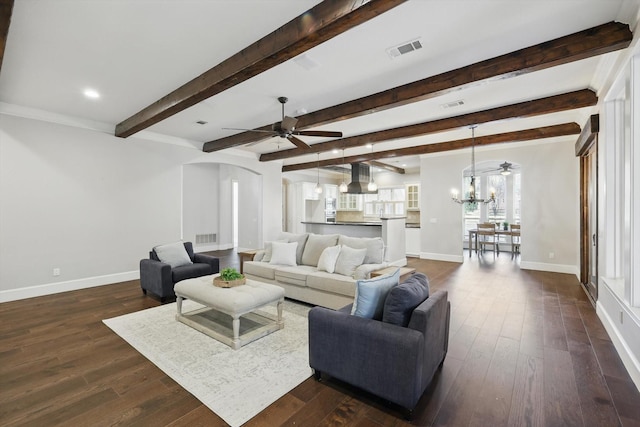 living area with dark wood finished floors, visible vents, and baseboards