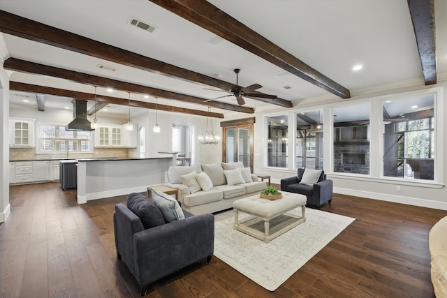 living room featuring visible vents, baseboards, beamed ceiling, and dark wood-style flooring